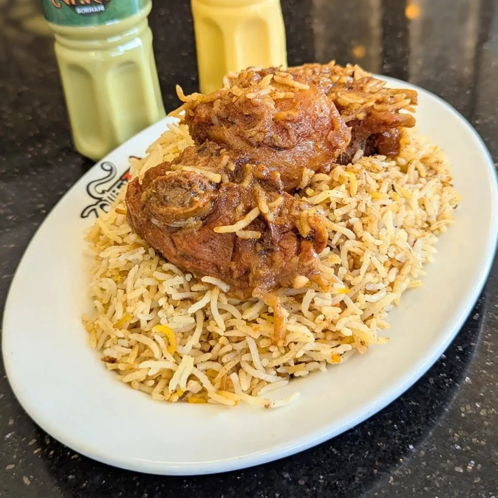 A plate of Basmati Mutton Kacchi from Kacchi Bhai with two pieces of tender mutton, one potato, basmati rice, and salad β served hot and aromatic.