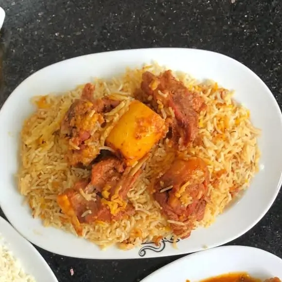 A large serving of Kacchi Khadok with 4 pieces of tender mutton, basmati kacchi rice, one potato, and fresh salad β served at Kacchi Bhai.
