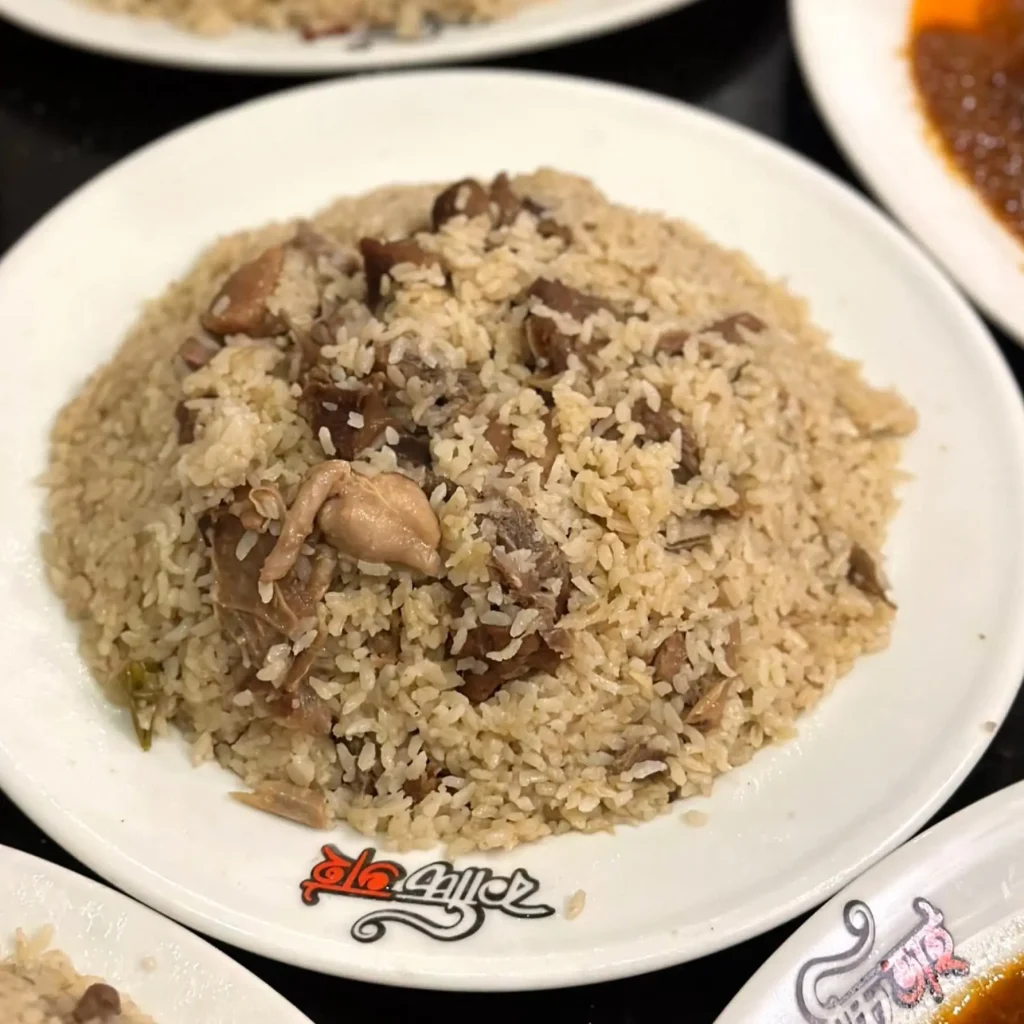 A plate of Mutton Teheri made with Chinigura rice, tender mutton pieces, and aromatic spices, served hot at Kacchi Bhai restaurant.