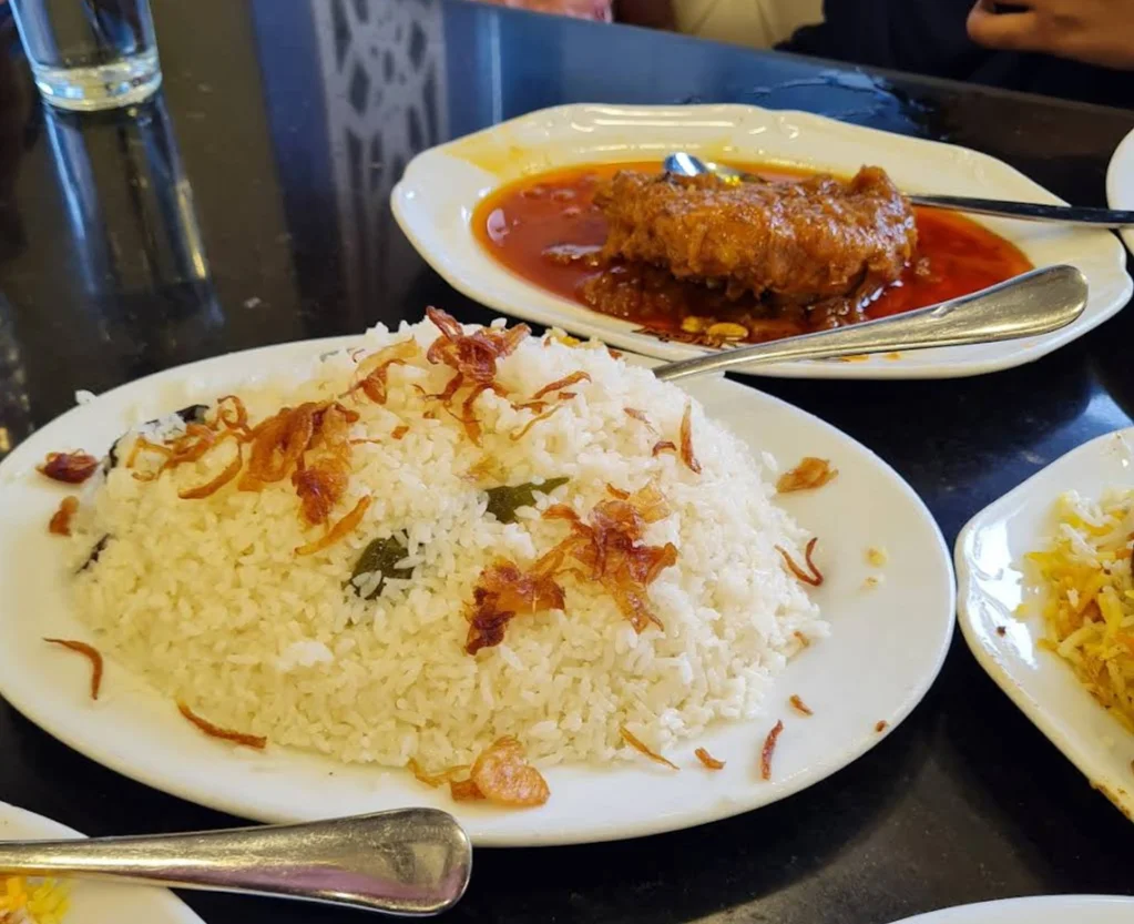 Delicious plain polao served with a flavorful chicken roast, garnished with crispy onions and spices.